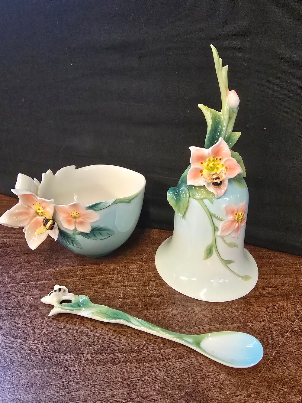 Lot 302: Franz Porcelain Apple Blossom & Honey Bee cup, bell, and spoon set