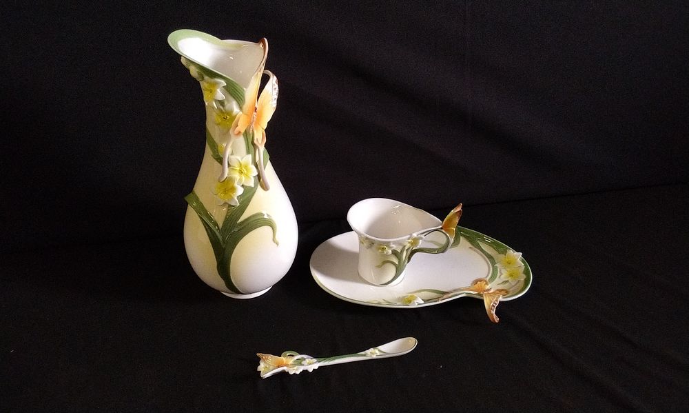 Lot 257: A Graff Porcelain Vase, Cup, Saucer/Tray and Spoon decorated with raised butterfly flowers and foliage,