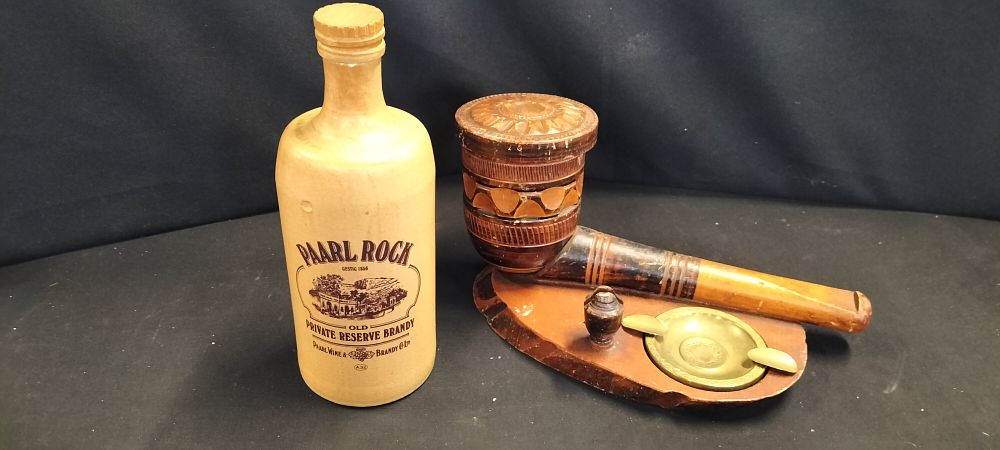 Lot 354: An Empty Paarl Rock Brandy Bottle and a Novelty Wooden Pipe-shaped Tobacco Pot and Ashtray