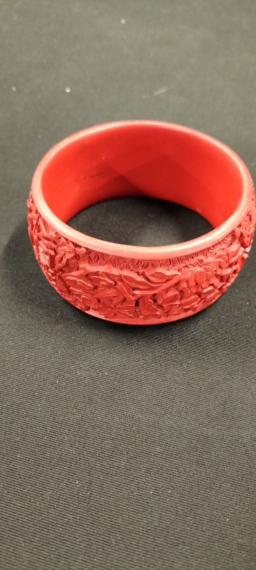 Lot 366: A Carved Faux Red Cinnabar Cuff Bracelet - Flowers, Fish and Asian Symbols