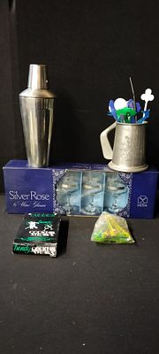 A Stainless Steel Cocktail Shaker with a Box of Cocktail Straws, Cocktail Stirrers, an Open 