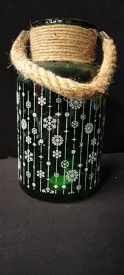 A Green Glass Christmas Lantern With a Snowflake Pattern and a Rope Handle