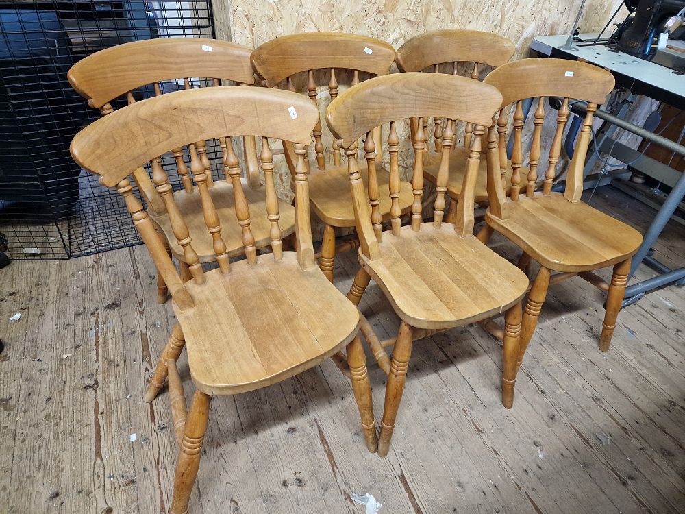 Lot 324: Six light brown wooden dining chairs, each featuring a spindle back and turned legs.