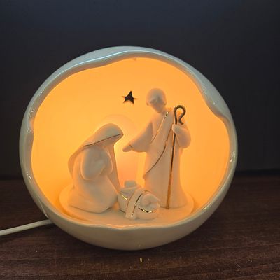 Lighted Ceramic Holy Family Nativity Globe Night Light. A single, glossy off-white ceramic 