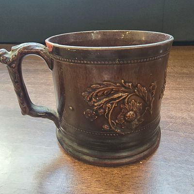 Dark Brown Ceramic Frog Mug Tankard with Embossed Foliate Relief. A single dark brown glossy 