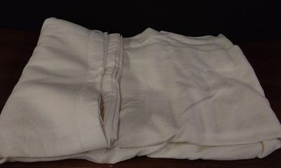 An Off-White Acrylic Blanket, Labeled as a Factory Second. A single utilitarian blanket 