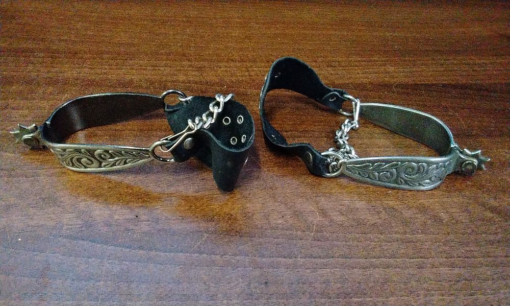 Lot 509: A Pair of Silver-Toned Western Spurs with Scrollwork