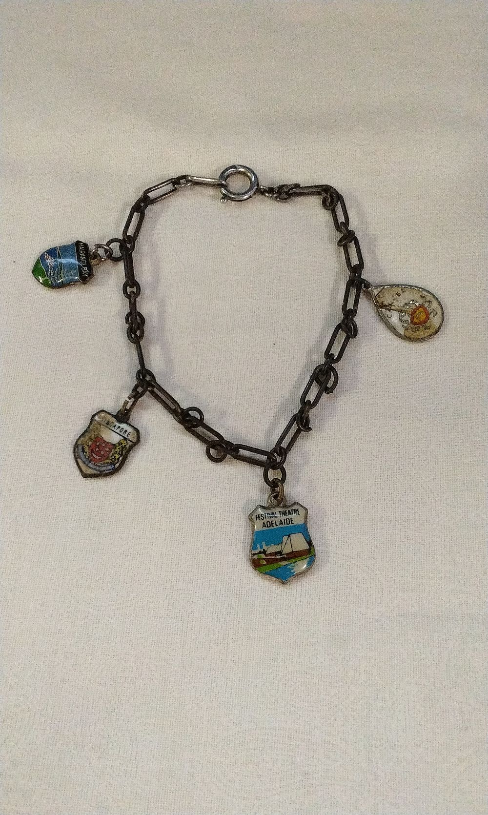 Lot 577: Vintage  Dark Metal Charm Bracelet with Four Enamel Travel Charms Some Silver
