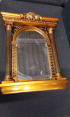 Gold-Toned Architectural Wall Mirror with Backing. A decorative, gold-toned architectural wall 