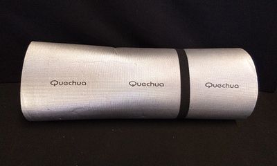 Quechua Silver and Brown Rolled Camping Mat. One silver and brown rolled camping mat or sleeping 