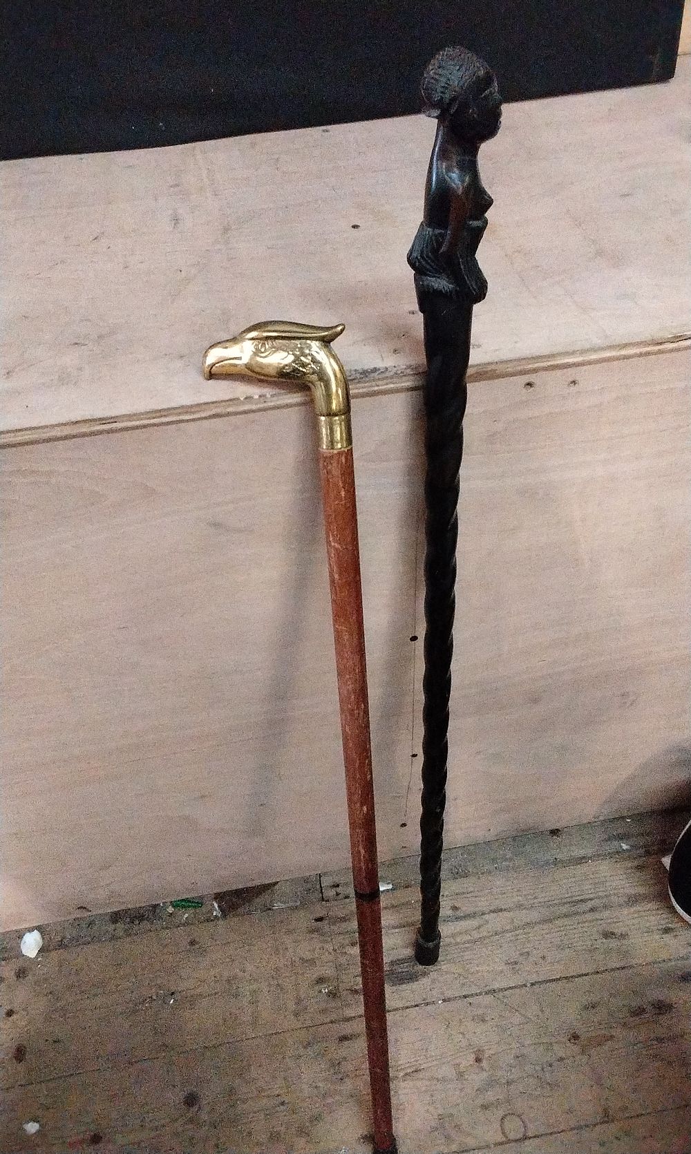 Lot 213: Two Walking Canes. One has a Brass Eagle Head, and One is a African Tribal Walking sSick, Hand Carved from Ebony Wood.