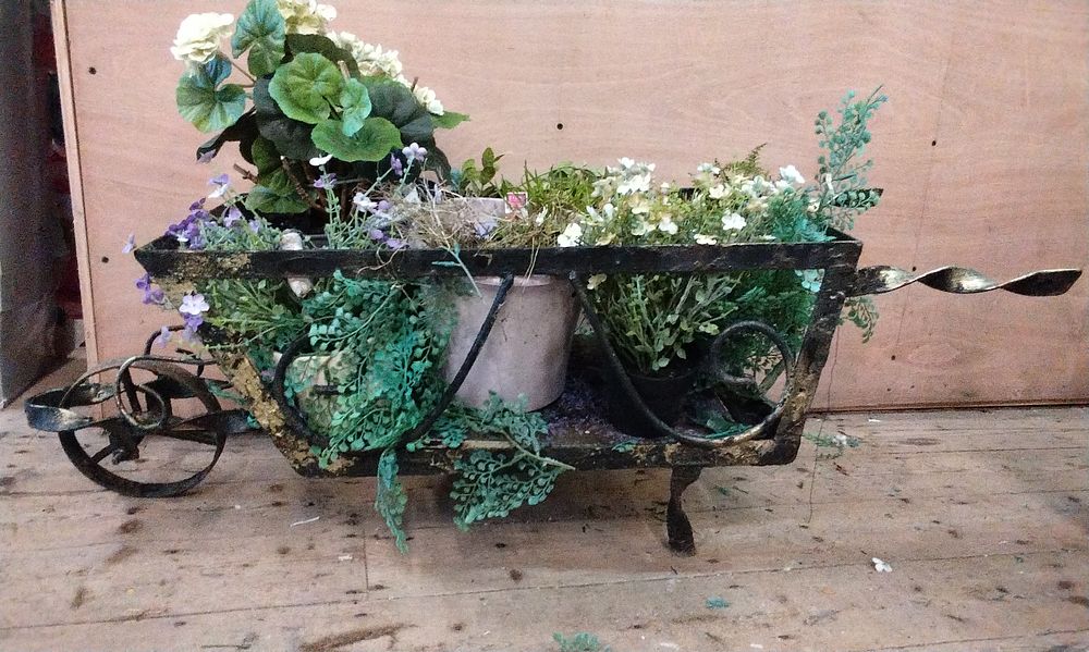 Lot 290: Decorative Cast Metal Planter Wheelbarrow Containing a Mix of Imitation and Real Plants. COLLECTION ONLY