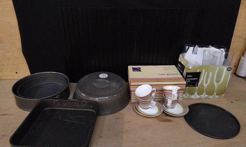 Lot 379: Selection of Mixed Household Items. Including Baking Tins, 4x Espresso Cups and Saucers, 5 Champagne Flutes, 2 Microwave Covers, and a Black Wood Slat Bath Mat