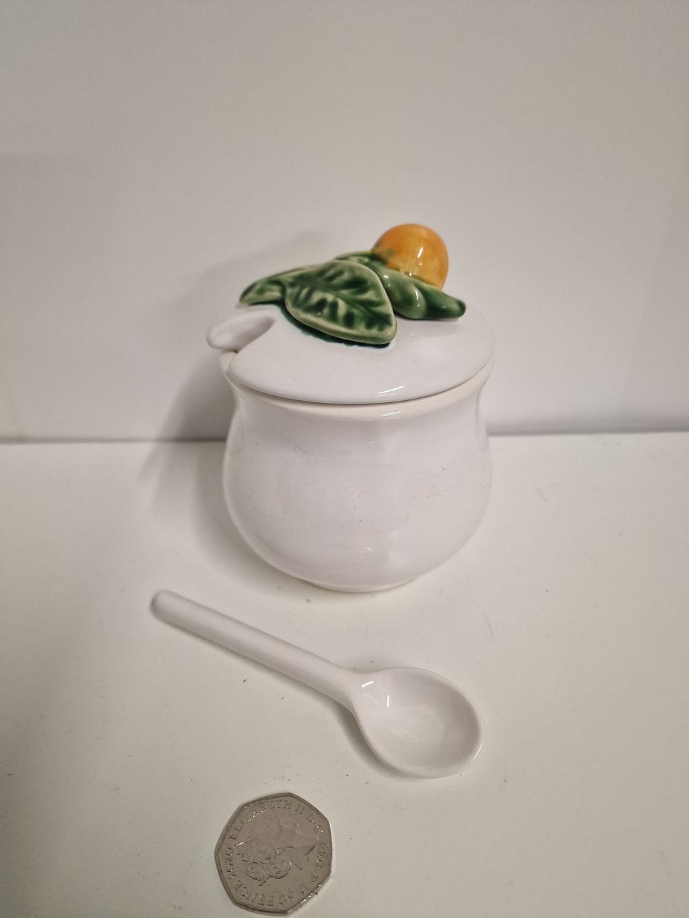 Lot 210: vintage Bordallo Pinheiro majolica white lemon pot, sugar pot, or jam pot with a lid and a ceramic spoon. 