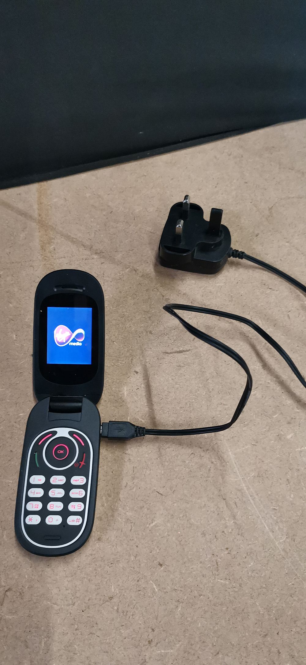 Lot 252: Alcatel flip phone with charging cable and UK adapter. Tested for Power