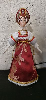 Russian folk doll in traditional red and gold dress. A Russian doll wearing a traditional red 