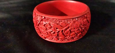Carved Red Cinnabar Style Floral Bangle Bracelet. A red cinnabar-style bangle bracelet featuring 