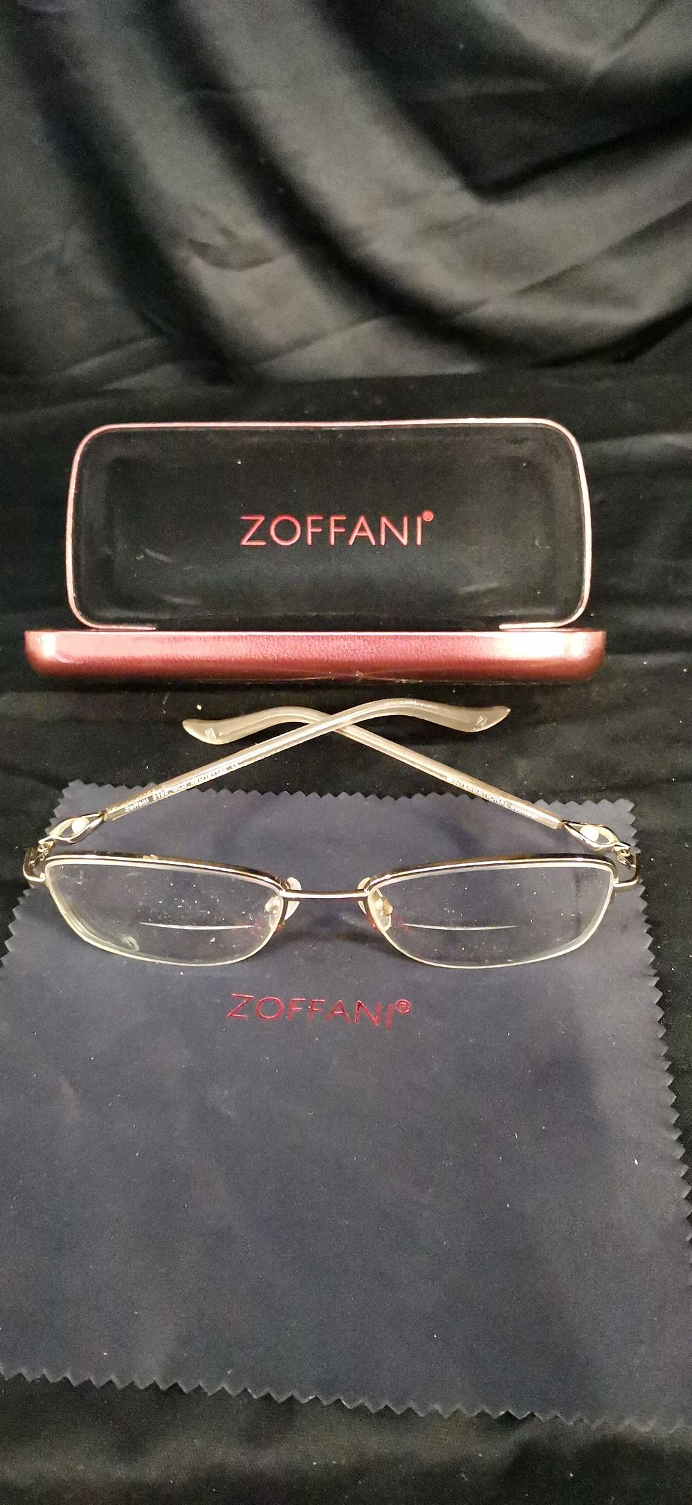 Lot 276: A pair of gold-toned Zoffani bifocal eyeglasses with accessories