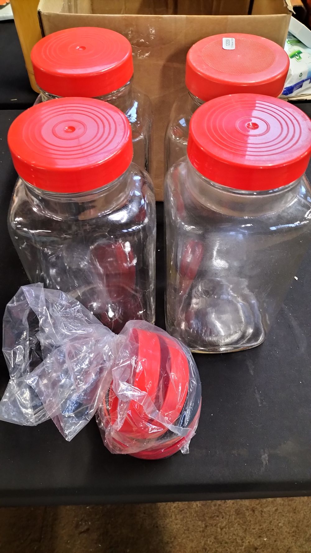 Lot 382: Four Clear Glass Storage Jars with Red Lids