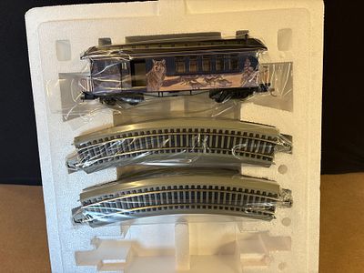 A Bachmann Hawthorne Village Passenger Car and Track Sections. A blue model train passenger car 