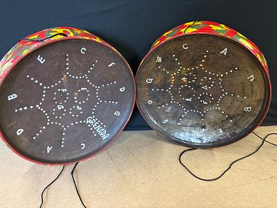 A Pair of Miniature Grenada Steel Drums. A pair of handmade steel drums featuring a dark brown 