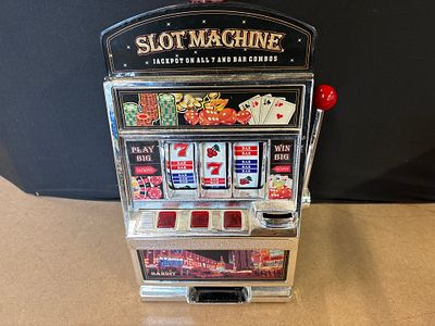 A Plastic Toy Slot Machine Bank with Red Accents. A plastic toy slot machine bank featuring a 