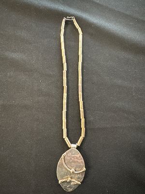 Silver-toned teardrop pendant necklace with cylindrical link chain. A silver-toned necklace 