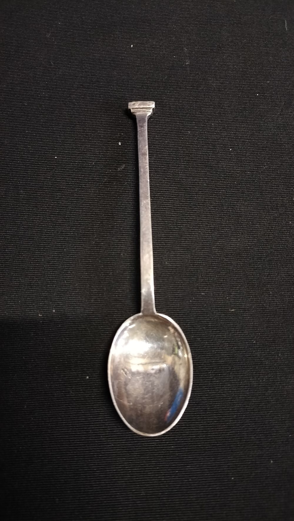 Lot 414: Silver-toned spoon with slender handle and rectangular finial
