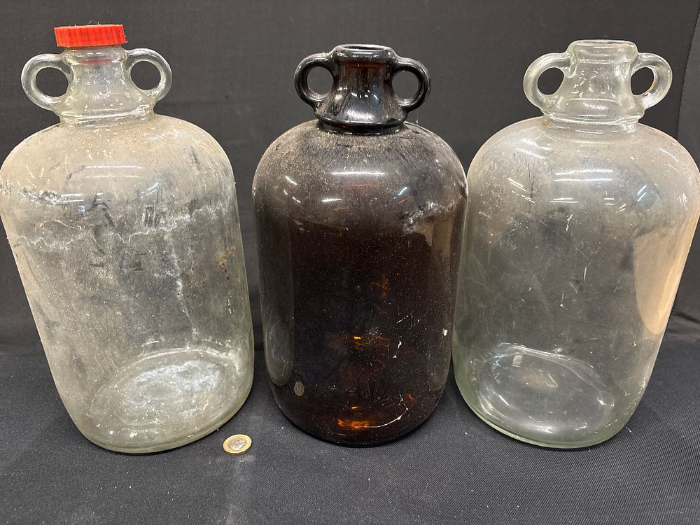 Lot 323: Three Coloured Glass Demijohns