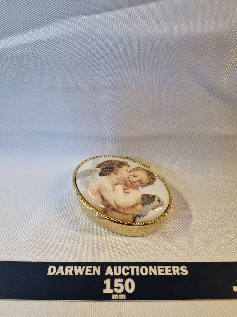 Lot 152: Vintage gilt-metal oval pill box with a classical cherub plaque
