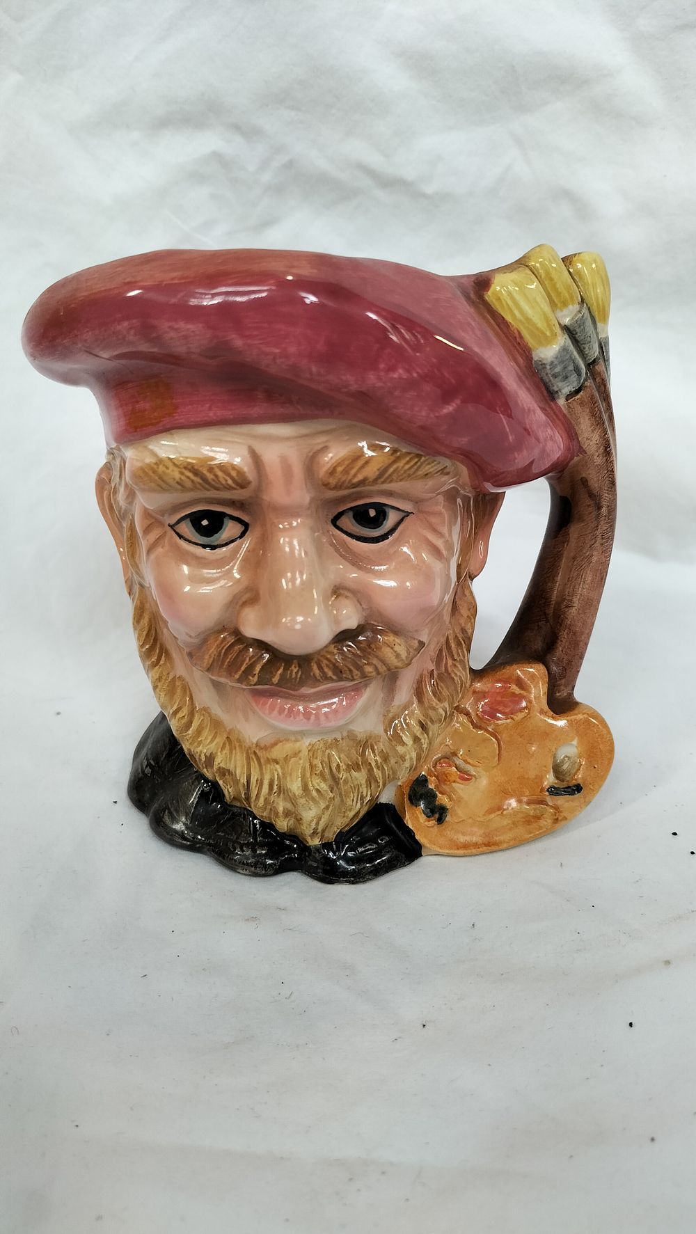 Lot 255: A polychrome glazed ceramic character jug depicting an artist