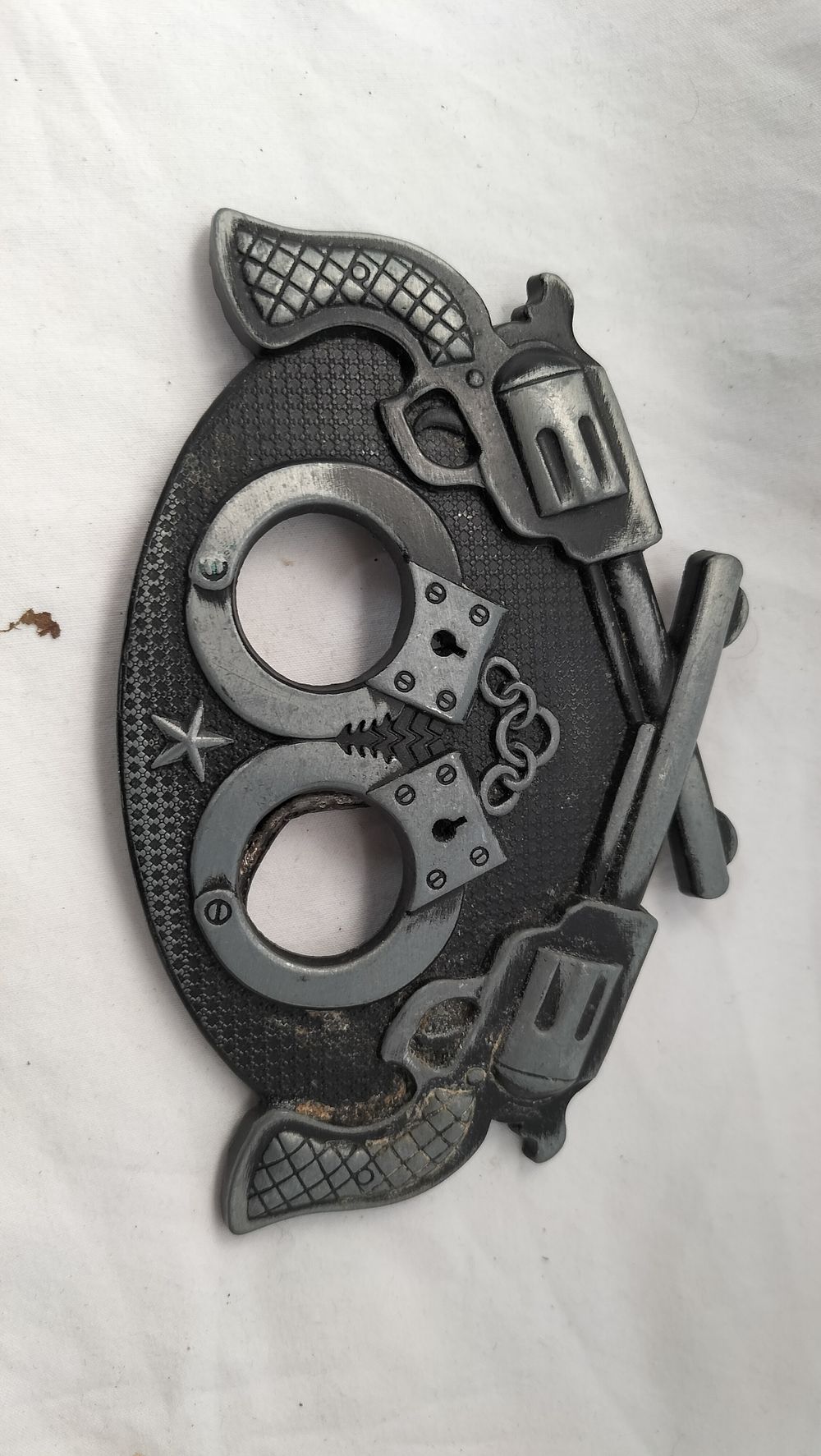 Lot 280: A Cast Metal Novelty Belt Buckle Featuring Crossed Revolvers and Handcuffs