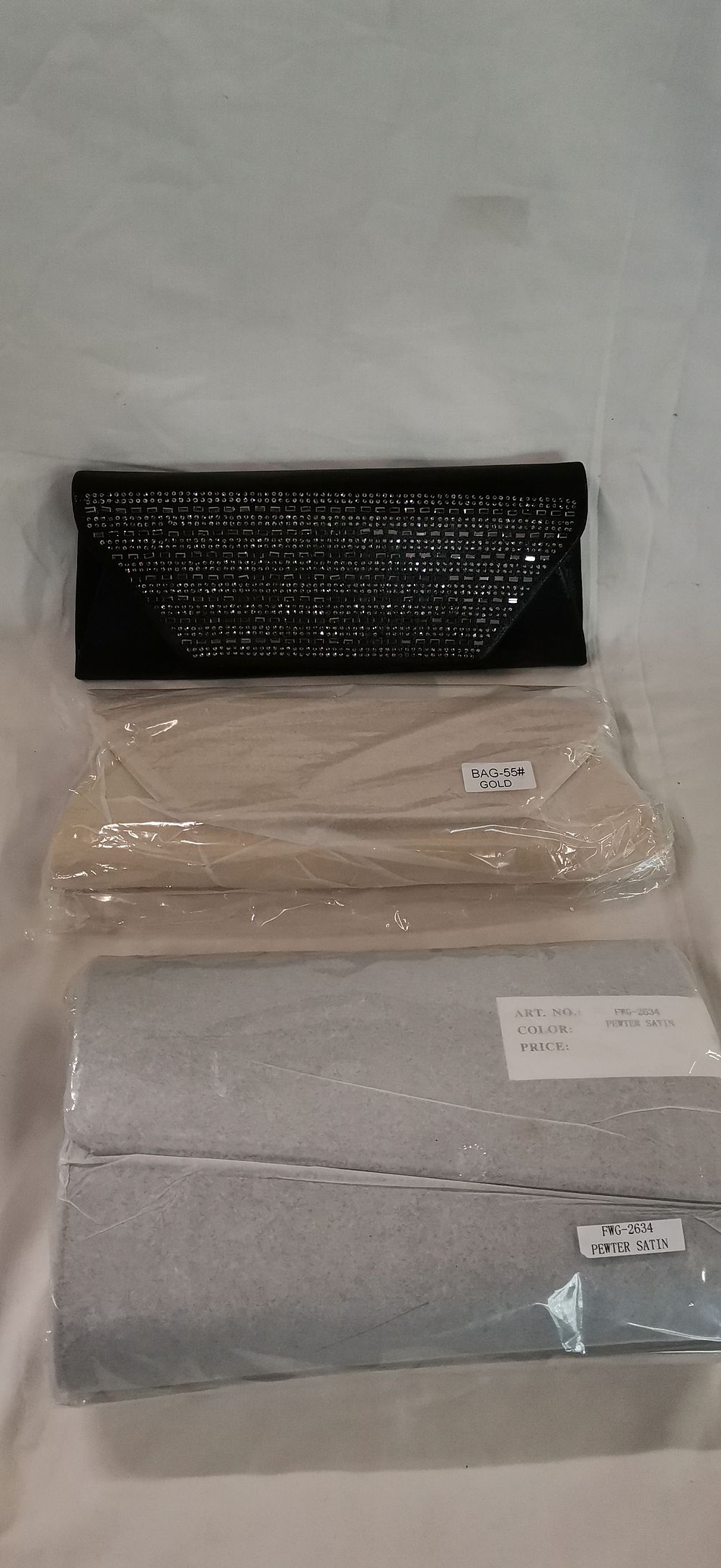 Lot 204: A Collection of Four Evening Clutch Bags in Black, Gold, and Pewter Satin