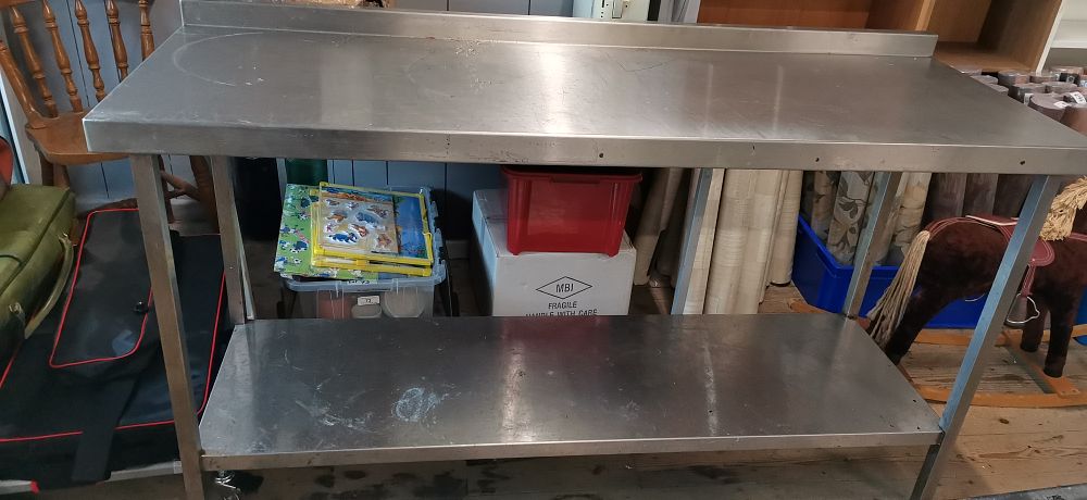 Lot 212: Commercial Stainless Steel Two Tier Work Table with Backsplash. Measures Approx H94 x W165 x D60cm. COLLECTION ONLY