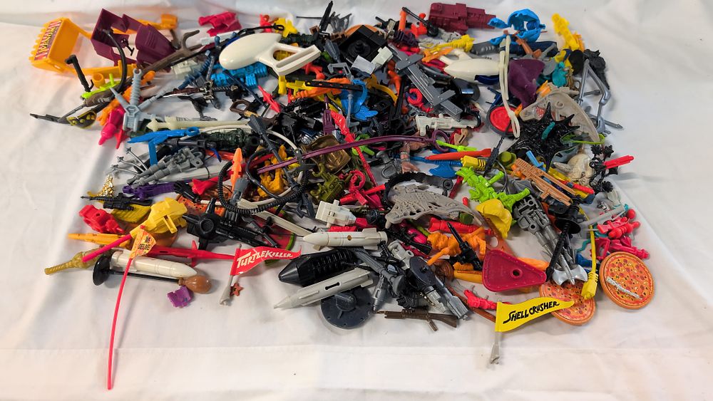 Lot 382: A Collection of Vintage Action Figure Accessories and Parts including TMNT, MOTU, and Lego Bionicle