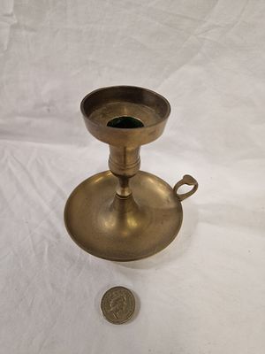 A vintage brass chamberstick with finger loop handle. A vintage brass chamberstick of cast and 