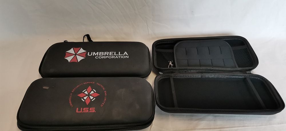 Lot 558: Three Resident Evil Umbrella Corporation and U.S.S. themed Nintendo Switch carrying cases