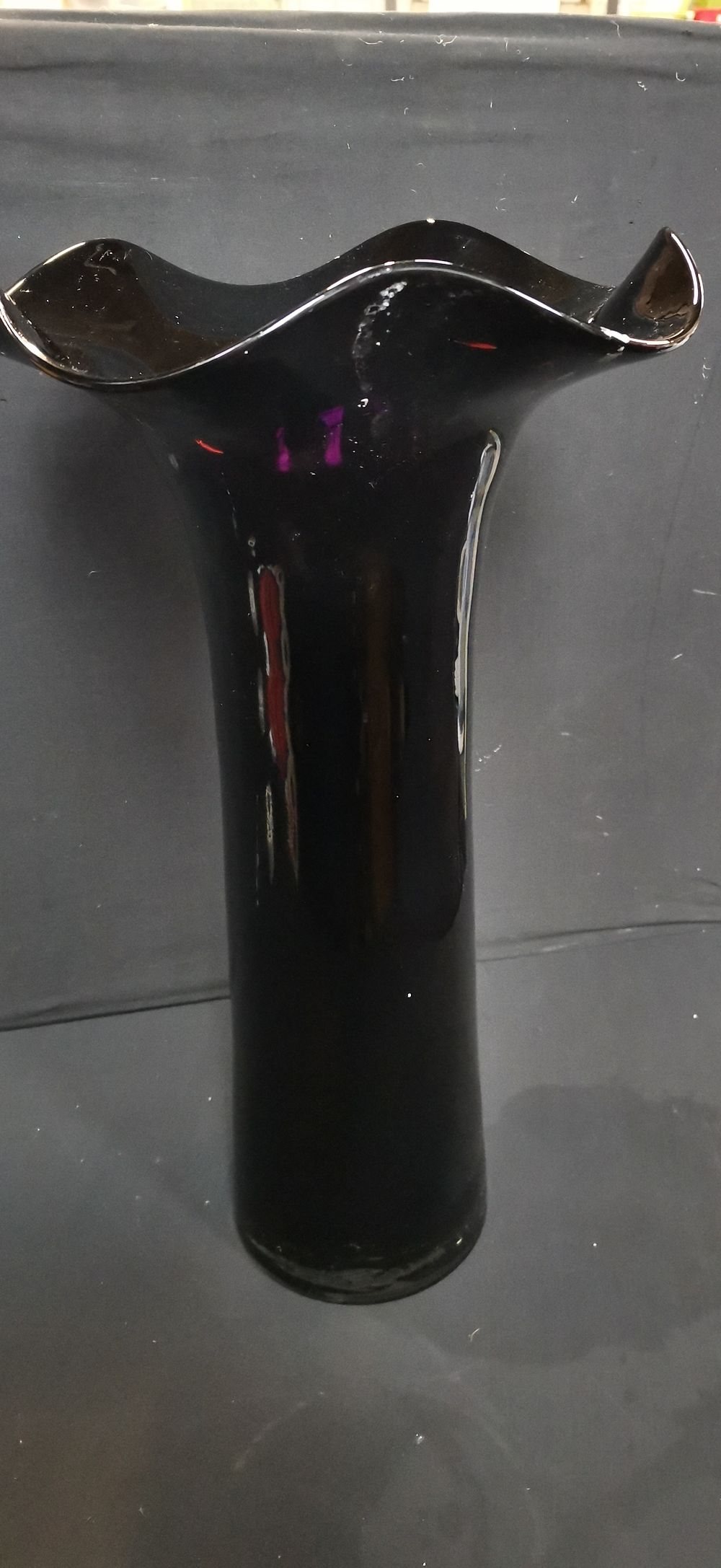 Lot 729: A tall black glass vase with scalloped rim. COLLECTION ONLY