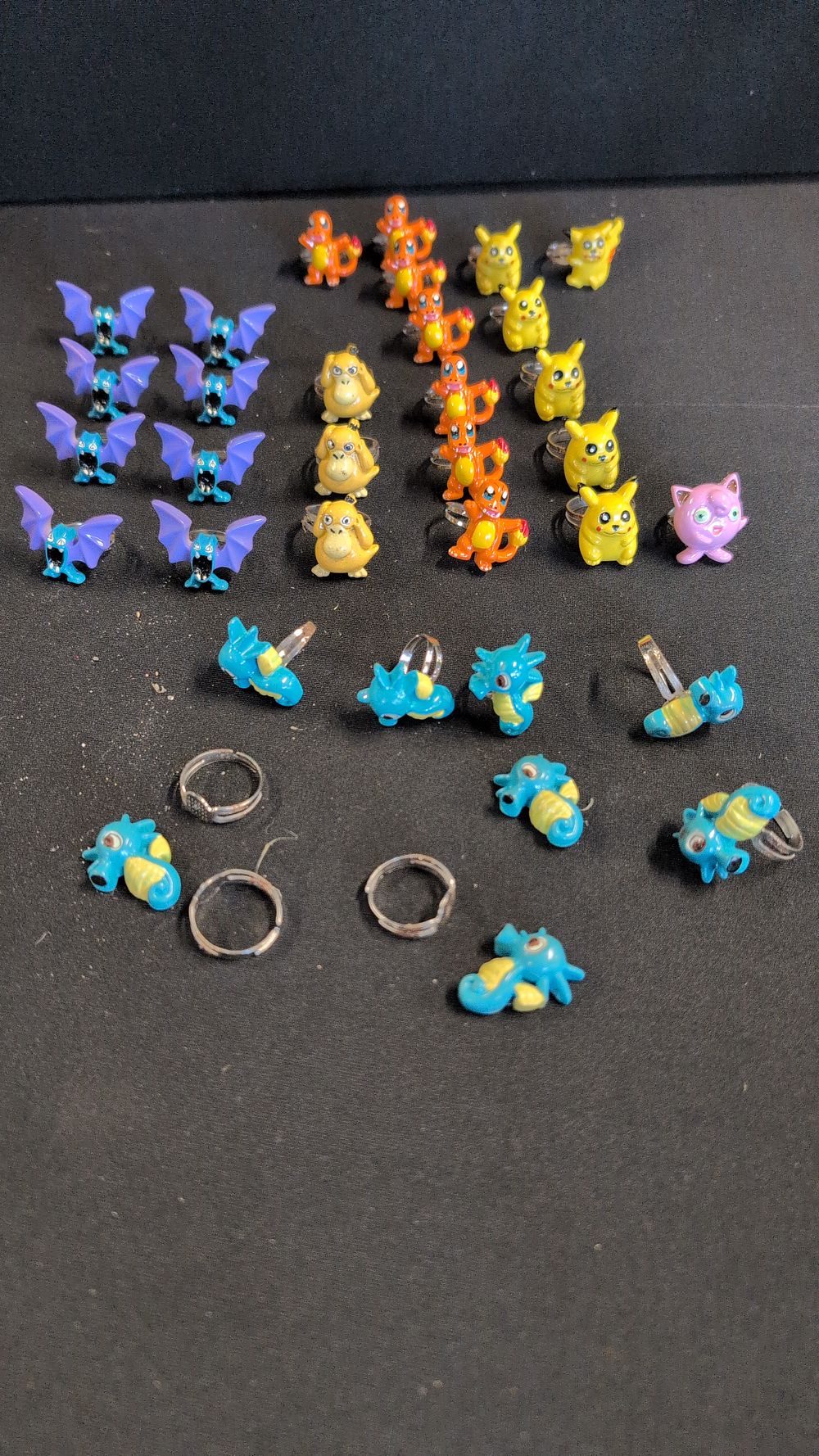 Lot 379: A Collection of 31 Novelty Character Rings and 3 Loose Bands in the Style of Pokemon