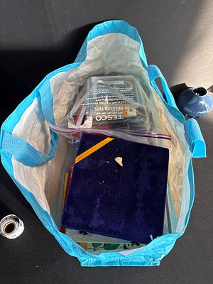 An Assortment of Metalware, Books, and Small Electronics within a Bag of Miscellaneous Items