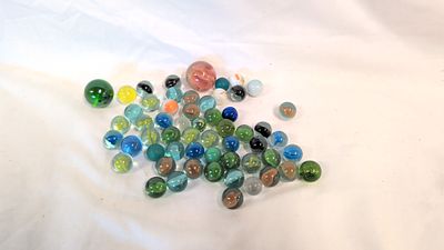 An Assortment of Coloured Glass Marbles with Cat's Eye and Swirl Patterns. A collection of glass 