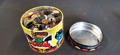 A Collection of Vintage Buttons and a Metal Bell in an Illustrated Circular Tin. An assortment 