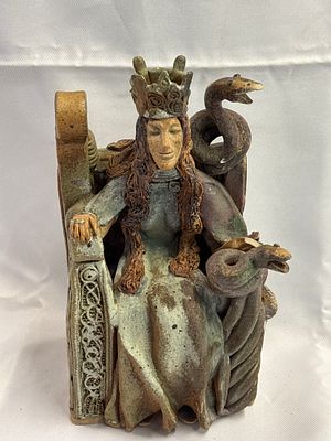 A contemporary ceramic sculptural group of a reclining goddess with serpents and Celtic knotwork. 
