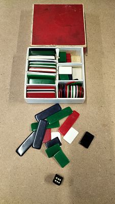 A Collection of Plastic Gaming Counters and Die. A collection of red, green, white, and black 