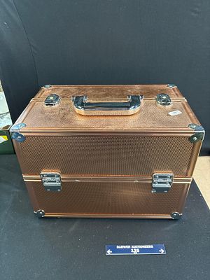 A copper coloured vanity case with rose gold-tone textured finish and cantilevered trays. This 