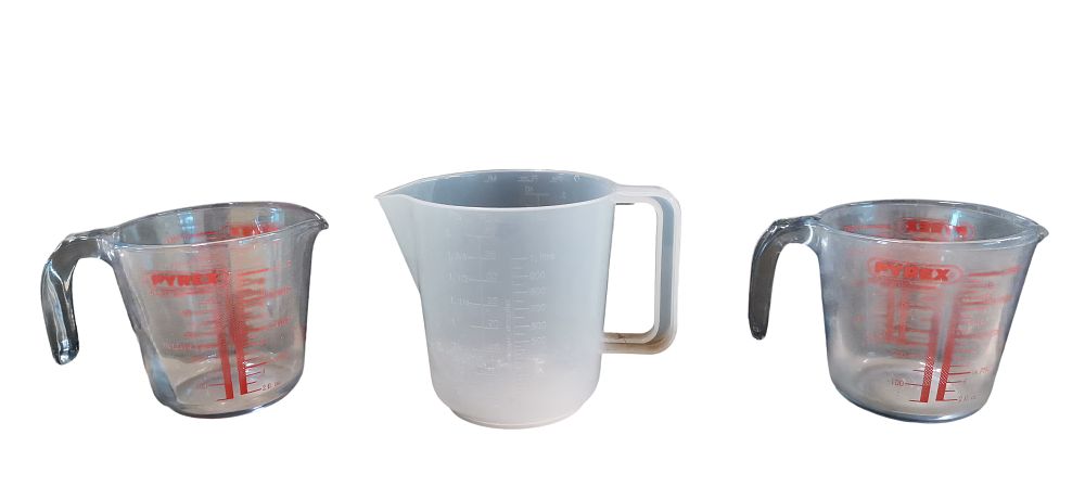 Lot 518: A Set of Three Kitchen Measuring Jugs comprising Two Pyrex Glass and One Plastic Example