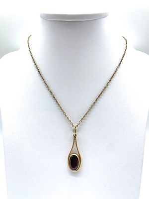 A 9ct yellow gold oval cut garnet pendant and chain, 16 inches long chain, pendant is 40mm long 