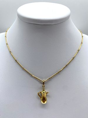 An 18ct yellow gold Egyptian jug pendant and chain, 18 inches long chain, jug is 30mm x 16mm 