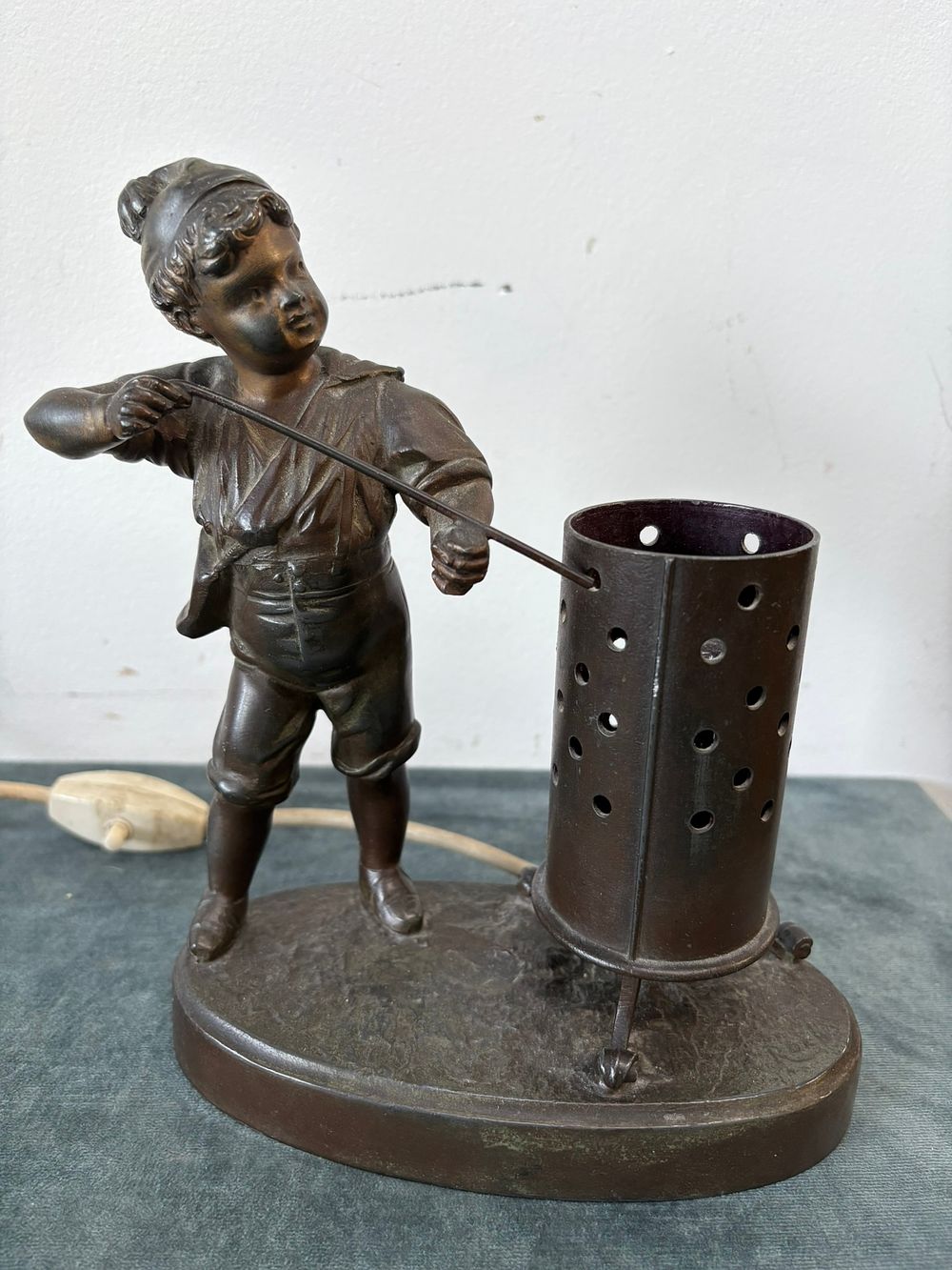 Lot 193: Bronzed spelter lamp of a boy lighting fire...