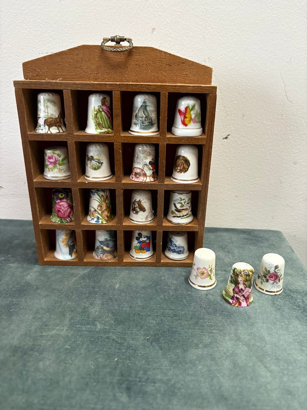 Lot 168: Assorted porcelain thimbles in wooden display stand